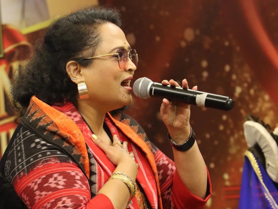 Dr. Jayashree Dhal singing with microphone