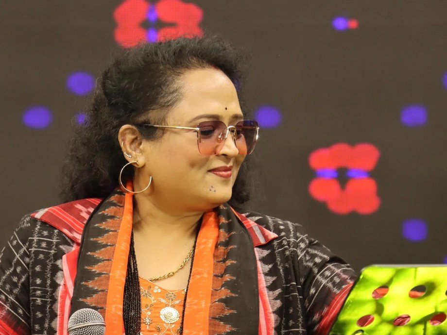 Dr. Jayashree Dhal on stage with microphone